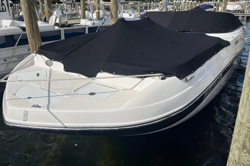 Slide: The Image of 2021 Hurricane SD 2486 boat docked with black cover, surrounded by other boats. - 2