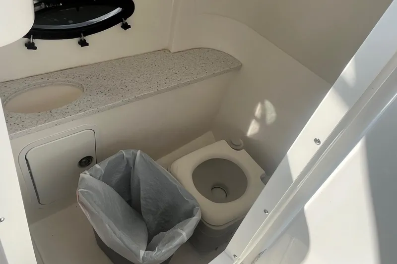 Slide: The Image of 2021 Hurricane SD 2486 boat bathroom with toilet, sink, and trash bin. - 20