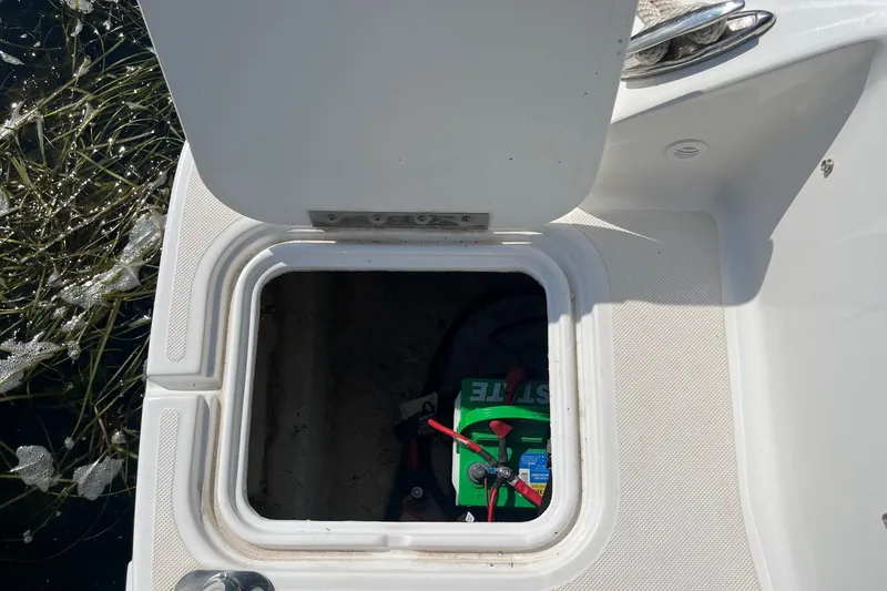 Slide: The Image of Open storage compartment on 2021 Hurricane SD 2486 boat, revealing a battery inside. - 7