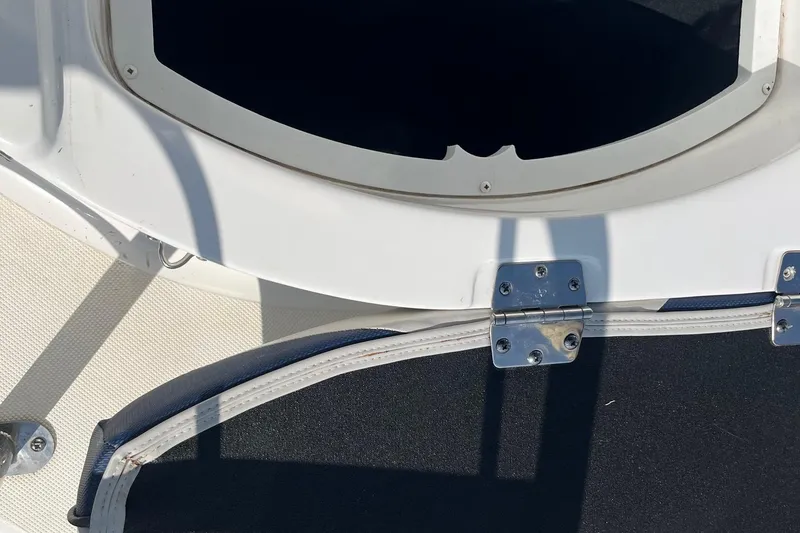Slide: The Image of 2021 Hurricane SD 2486 boat hatch with metal hinges and white trim. - 9