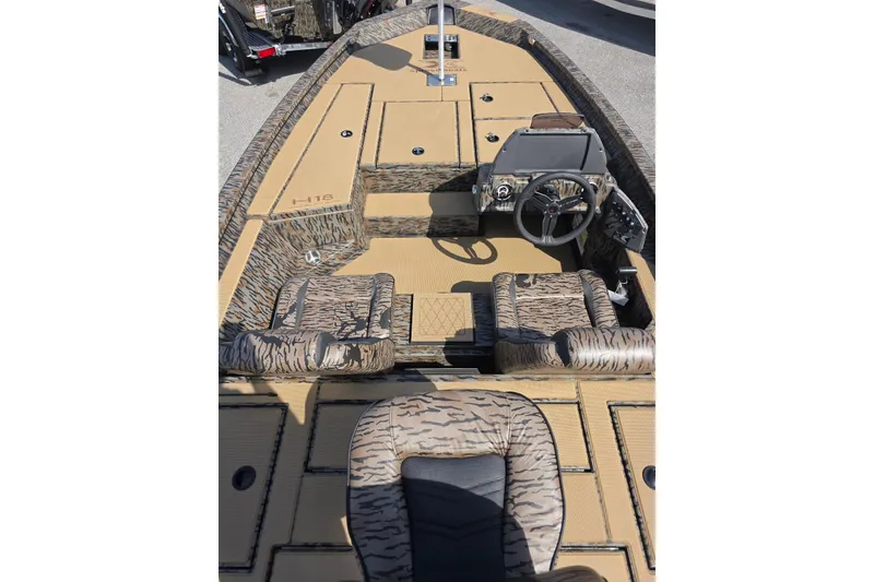 Slide: The Image of 2026 Xpress H18 Bass boat interior with camouflage seating and steering console. - 12