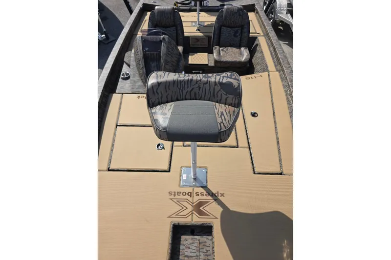 Slide: The Image of 2026 Xpress H18 Bass boat interior with camo seats and storage compartments. - 18