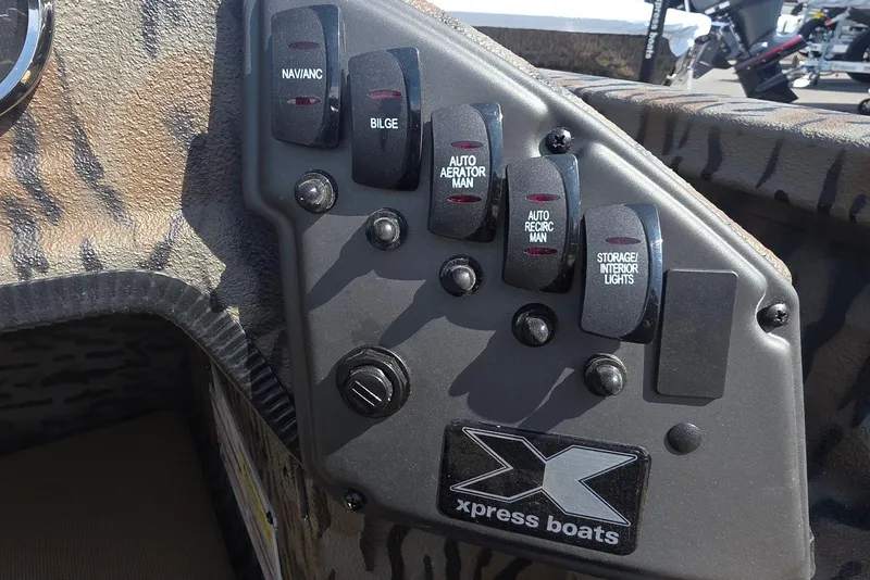 Slide: The Image of Control panel of 2026 Xpress H18 Bass boat with various switches and logo. - 22