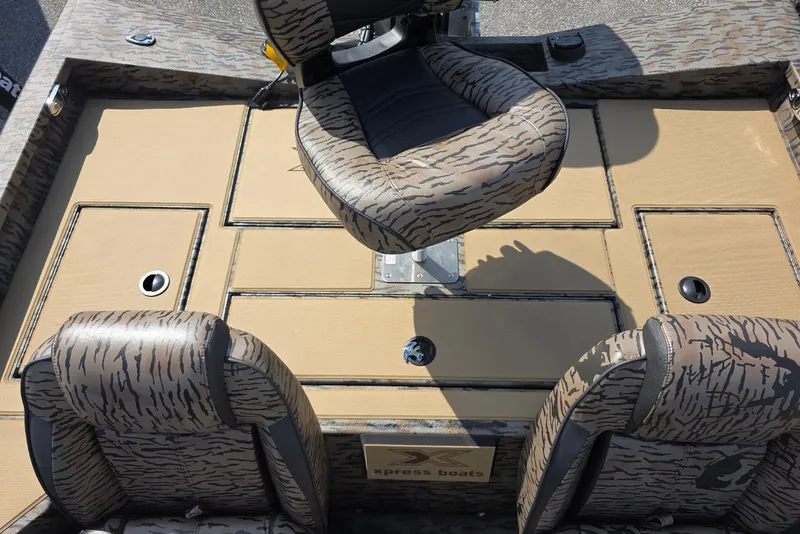 Slide: The Image of 2026 Xpress H18 Bass boat interior with camo seats and storage compartments. - 24