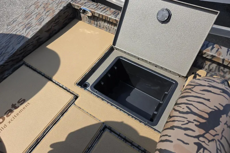 Slide: The Image of Open storage compartment on 2026 Xpress H18 Bass boat with camouflage design. - 27