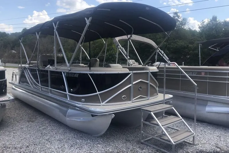 Slide: The Image of 2018 South Bay 822 CR pontoon boat with canopy, parked on gravel lot. - 1