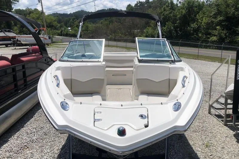 Slide: The Image of 2011 Chaparral 206 SSi boat with open bow seating, parked outdoors. - 11