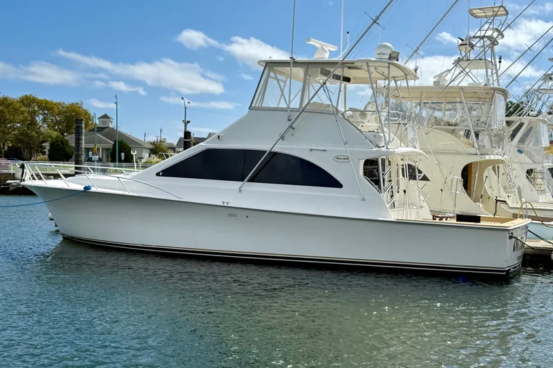 Slide: The Image of 2000 Ocean Yachts 48 model docked in a marina under a clear blue sky. - 0