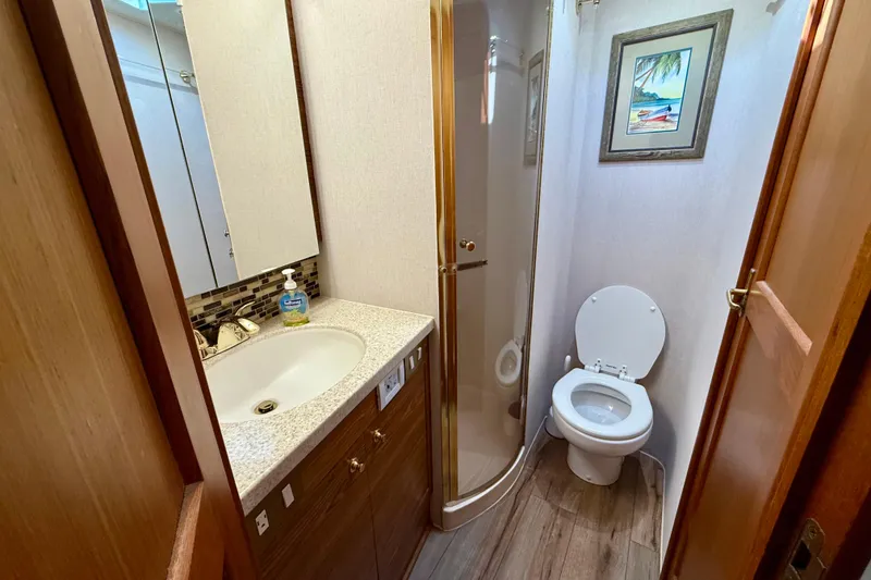 Slide: The Image of Bathroom interior of 2000 Ocean Yachts 48, featuring shower, sink, and toilet. - 12