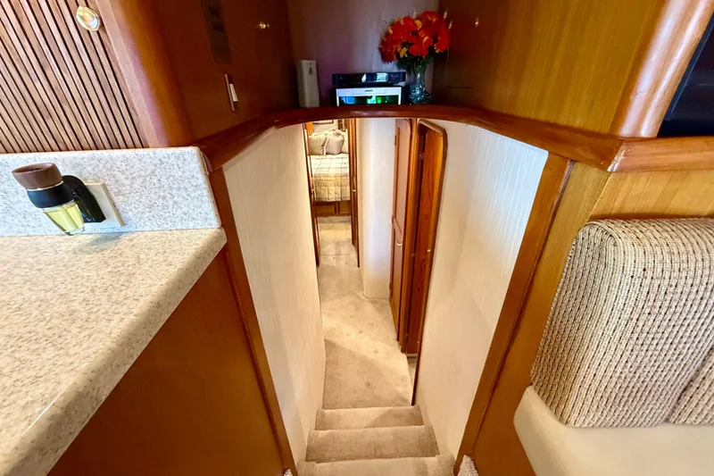 Slide: The Image of Interior view of 2000 Ocean Yachts 48, featuring a cozy staircase and elegant wood finishes. - 13