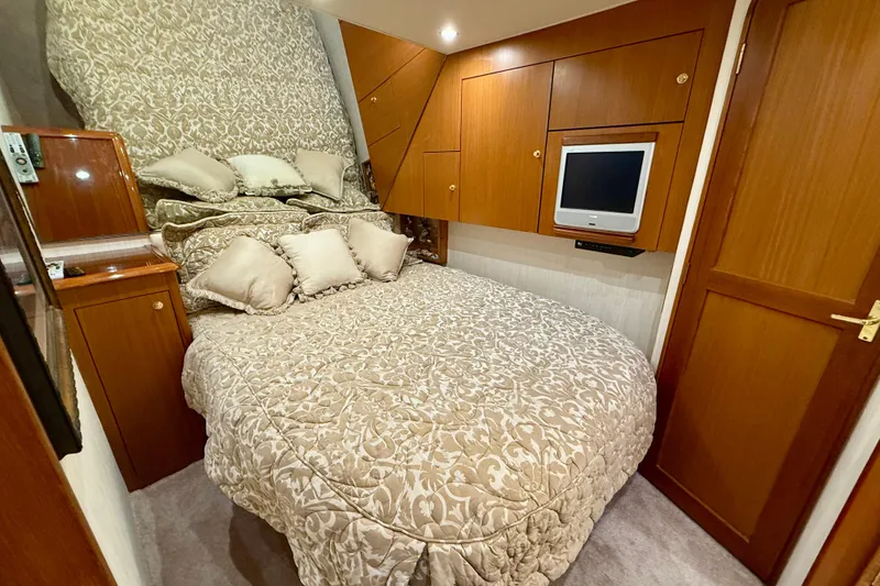 Slide: The Image of Luxurious bedroom in 2000 Ocean Yachts 48, featuring elegant bedding and wood cabinetry. - 14