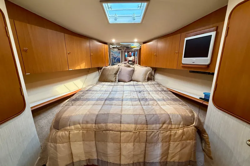 Slide: The Image of Luxurious bedroom interior of 2000 Ocean Yachts 48, featuring cozy bedding and wooden cabinetry. - 15