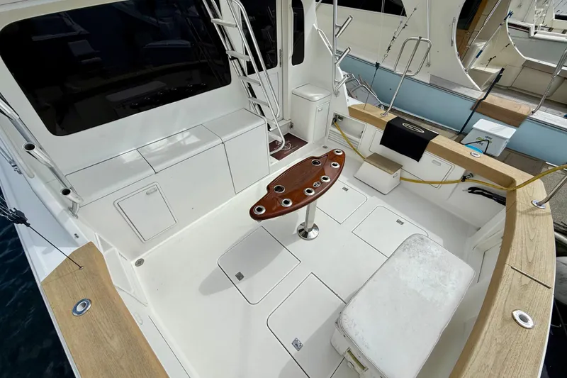 Slide: The Image of Spacious deck of a 2000 Ocean Yachts 48, featuring seating and fishing rod holders. - 31