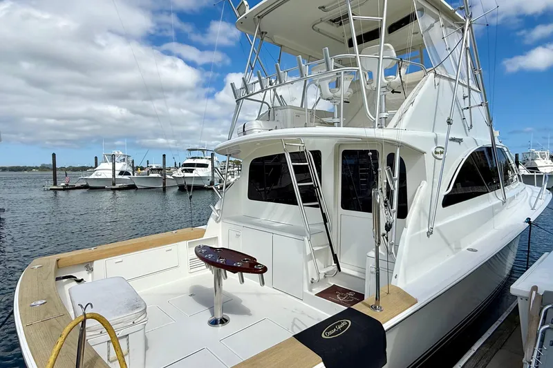 Slide: The Image of 2000 Ocean Yachts 48 docked, showcasing sleek design and spacious deck under a blue sky. - 39