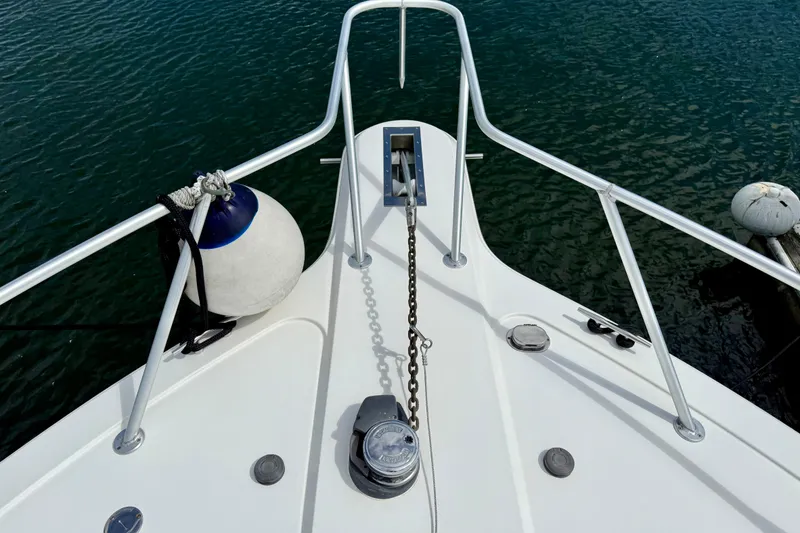 Slide: The Image of Bow of 2000 Ocean Yachts 48, featuring anchor chain and fender on calm water. - 40