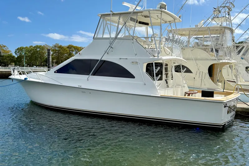 Slide: The Image of 2000 Ocean Yachts 48 model docked in a marina under a clear blue sky. - 41
