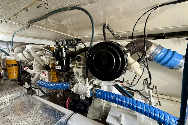 Slide: The Image of Engine room of a 2000 Ocean Yachts 48, featuring Caterpillar machinery and blue hoses. - 5
