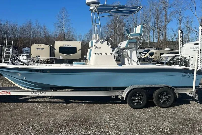 The Image of 2021 Shallow Sport 24 Modified V boat on water, with person onboard, surrounded by greenery. - 0