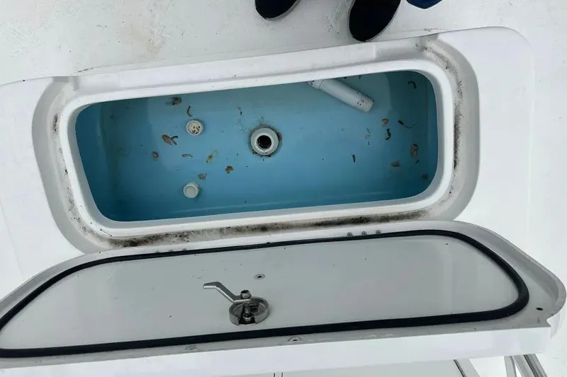 Slide: The Image of 2021 Shallow Sport 24 Modified V boat on water, with lush greenery in the background. - 12