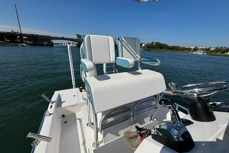 Slide: The Image of 2021 Shallow Sport 24 Modified V boat interior with helm and seating on water. - 13