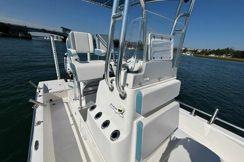 Slide: The Image of 2021 Shallow Sport 24 Modified V boat on water, featuring sleek design and comfortable seating. - 14