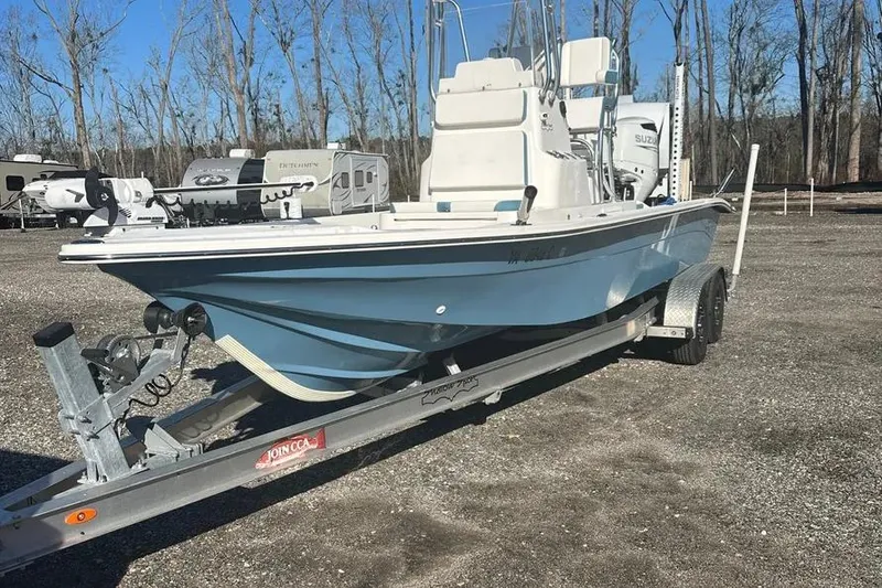 Slide: The Image of 2021 Shallow Sport 24 Modified V boat on water, featuring Suzuki engine and fishing equipment. - 2