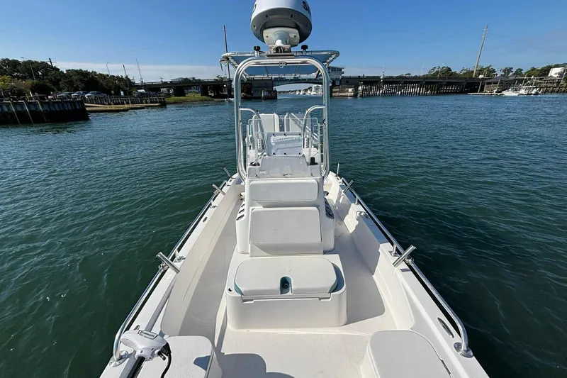 Slide: The Image of 2021 Shallow Sport 24 Modified V boat on calm water, showcasing sleek design and spacious deck. - 20