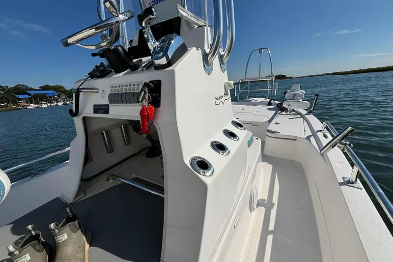 Slide: The Image of 2021 Shallow Sport 24 Modified V boat on water, showcasing console and deck features. - 22