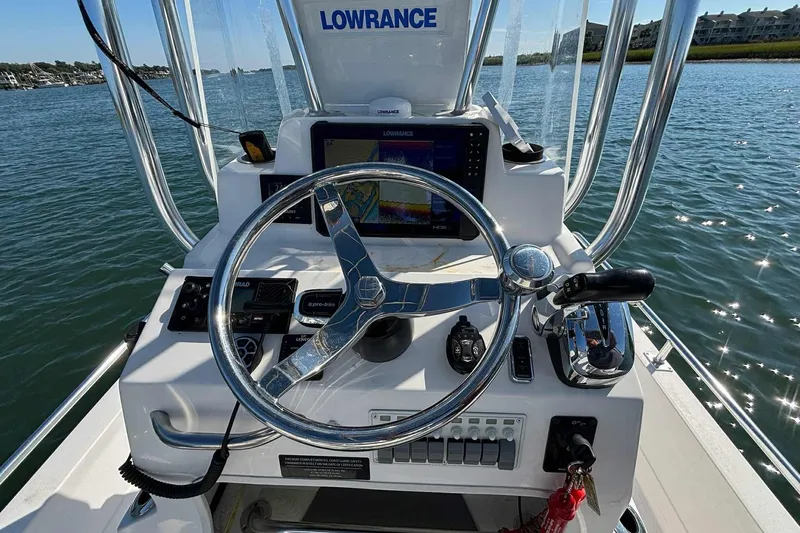 Slide: The Image of 2021 Shallow Sport 24 Modified V boat console with Lowrance navigation system on water. - 23