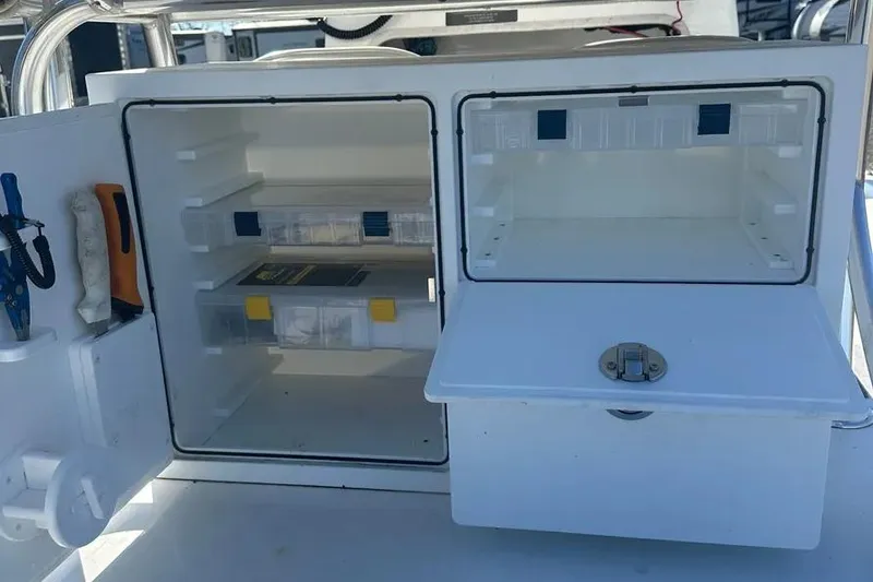 Slide: The Image of 2021 Shallow Sport 24 Modified V boat storage compartments with tools and tackle boxes. - 28