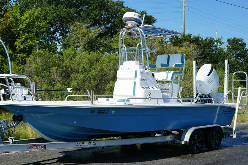 Slide: The Image of 2021 Shallow Sport 24 Modified V boat on trailer, blue hull, outdoor setting. - 31