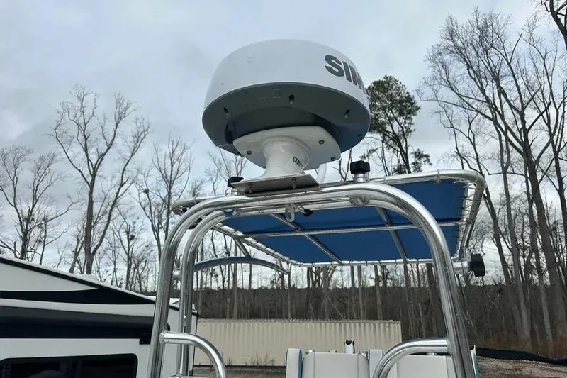 Slide: The Image of 2021 Shallow Sport 24 Modified V boat cruising on water with lush greenery in the background. - 6