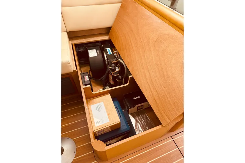 Slide: The Image of Storage compartment in 2008 Jeanneau Sun Odyssey 45 DS yacht, showcasing equipment and wooden finish. - 54