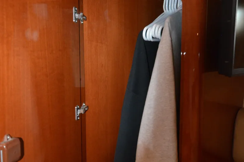 Slide: The Image of Wooden closet interior on a 2007 Jeanneau Prestige 46 yacht with hanging clothes. - 39