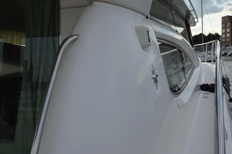 Slide: The Image of 2007 Jeanneau Prestige 46 yacht side view with sleek design and marina background. - 6