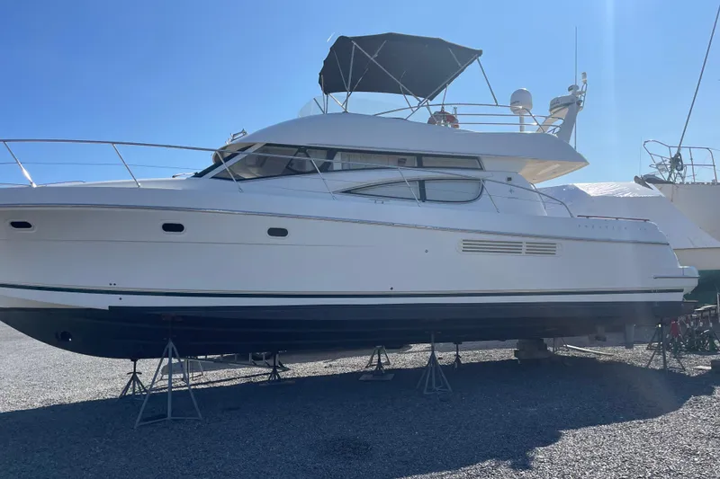 Slide: The Image of 2007 Jeanneau Prestige 46 yacht on stands, side view under clear blue sky. - 63