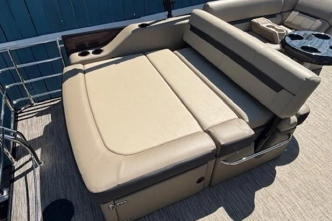 Slide: The Image of 2024 Godfrey SWEETWATER 2286 SFL boat interior with beige seating and cup holders. - 29