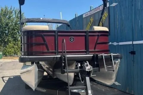 Slide: The Image of 2024 Godfrey SWEETWATER 2286 SFL pontoon boat, maroon exterior, parked on trailer. - 5