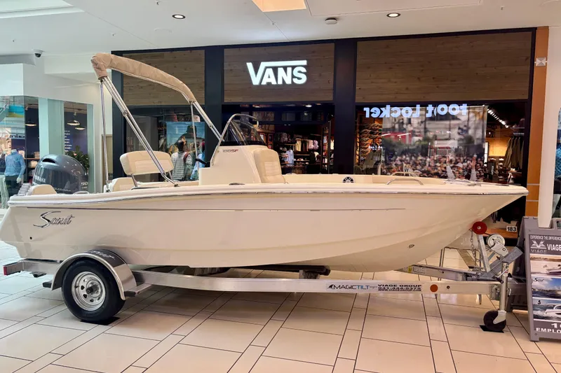 The Image of 2026 Scout 188 Sportfish boat displayed indoors on a trailer, near retail stores. - 0