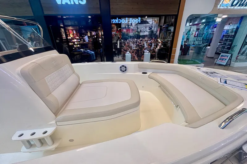 Slide: The Image of 2026 Scout 188 Sportfish boat interior with beige seating, displayed in a showroom. - 10