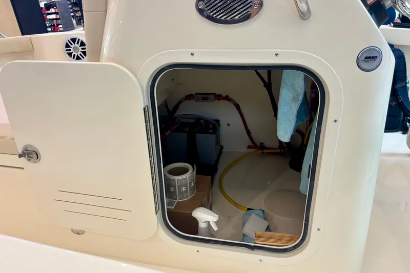 Slide: The Image of Open storage compartment on 2026 Scout 188 Sportfish boat, showing interior equipment and supplies. - 15