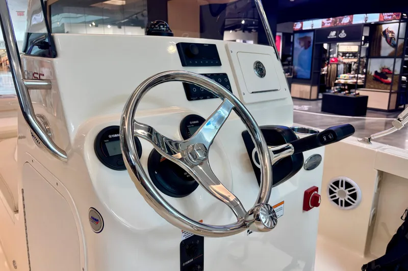 Slide: The Image of 2026 Scout 188 Sportfish boat helm with steering wheel and controls in showroom. - 6