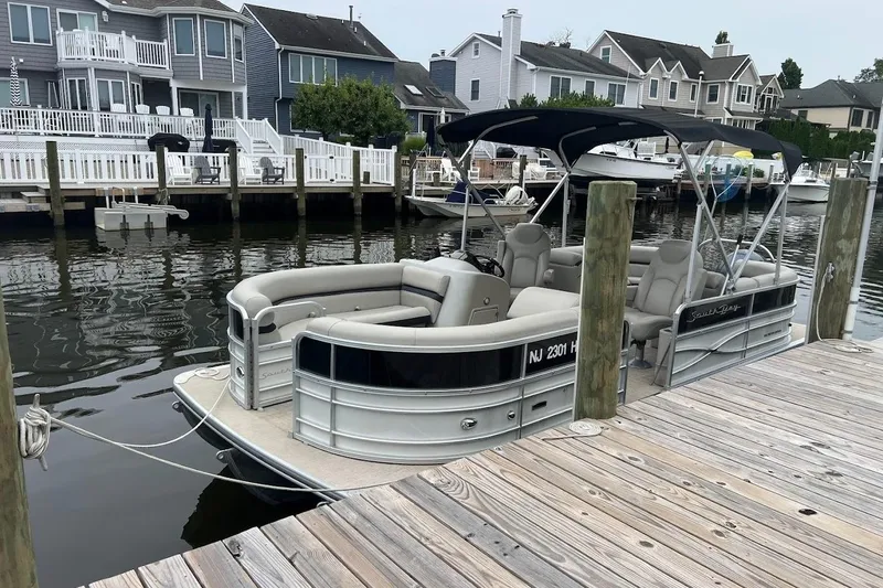 Slide: The Image of 2018 South Bay 224RS pontoon boat docked by waterfront homes. - 14