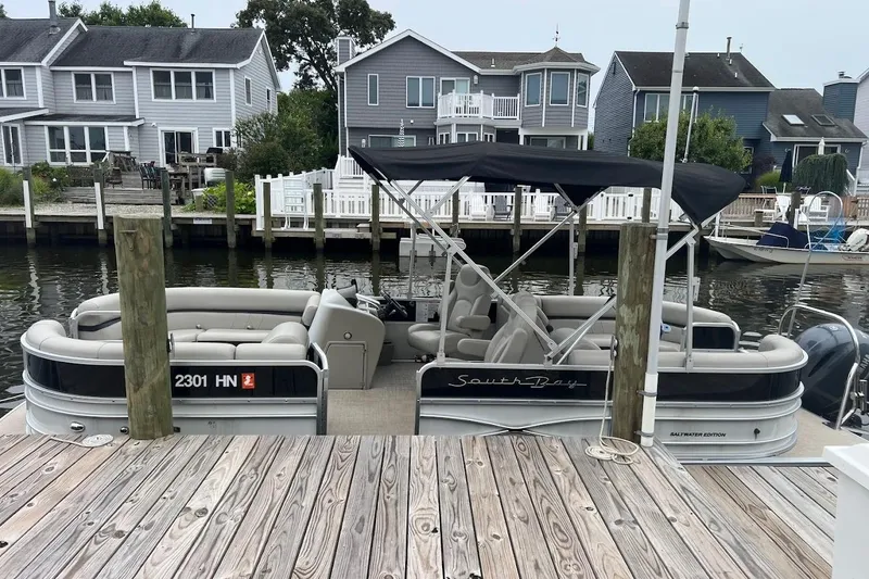 Slide: The Image of 2018 South Bay 224RS pontoon boat docked by waterfront homes. - 15