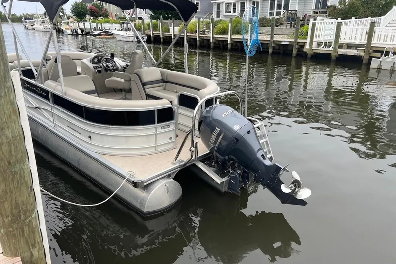 Slide: The Image of 2018 South Bay 224RS pontoon boat with Yamaha engines, parked on gravel. - 2