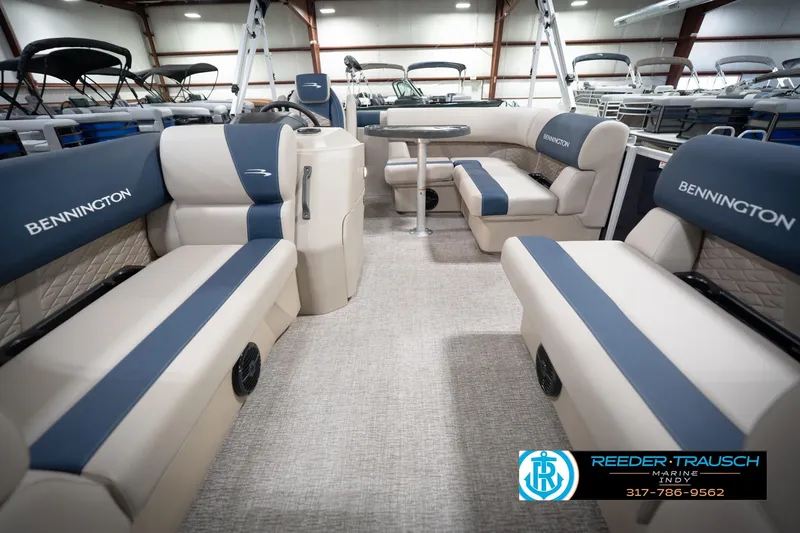 Slide: The Image of 2026 Bennington 168 SLJ boat interior with beige and blue seating, steering console, and table. - 16
