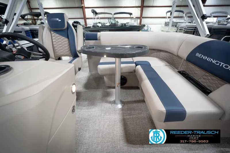 Slide: The Image of 2026 Bennington 168 SLJ pontoon boat interior with blue and beige seating, showcased indoors. - 17