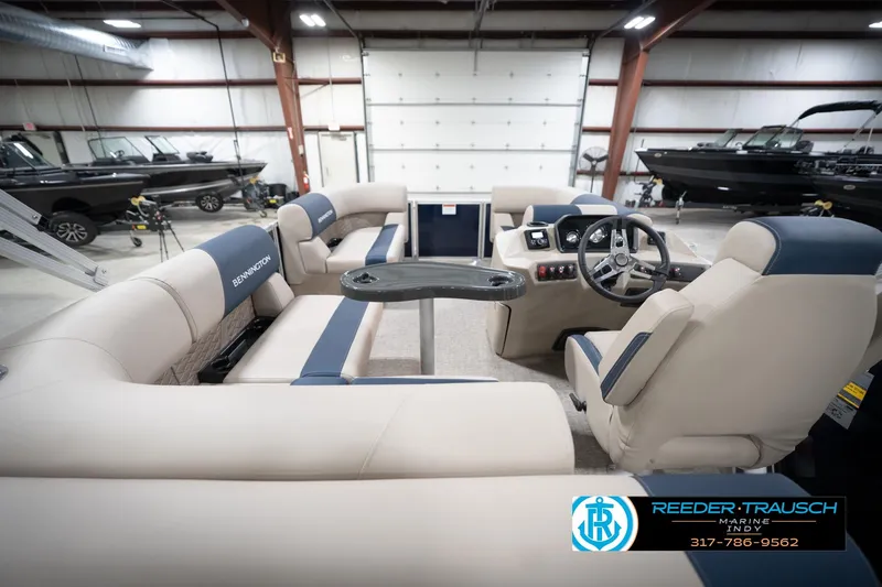 Slide: The Image of 2026 Bennington 168 SLJ boat interior with beige and blue seating, showroom display. - 19