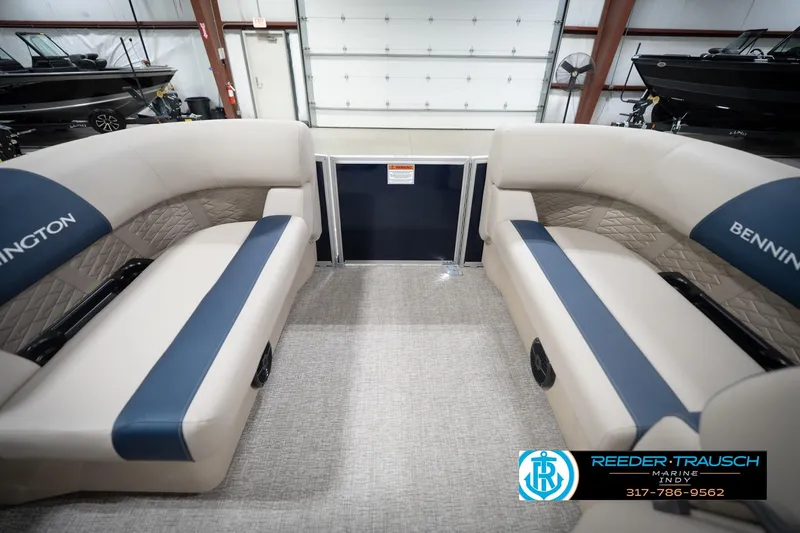 Slide: The Image of 2026 Bennington 168 SLJ pontoon boat interior with beige and blue seating in a showroom. - 21