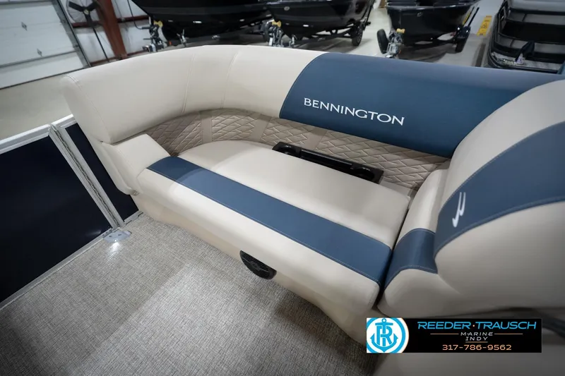 Slide: The Image of 2026 Bennington 168 SLJ boat interior with beige seating and cup holders in showroom. - 24